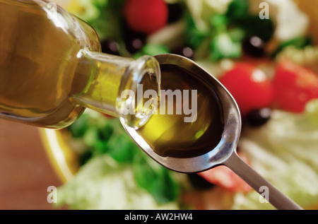 Olive oil pouring on to a spoon Stock Photo