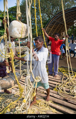 Fishermen pulling Chinese fishing net ropes, Fort Cochin, Cochin, Kerala, India Stock Photo
