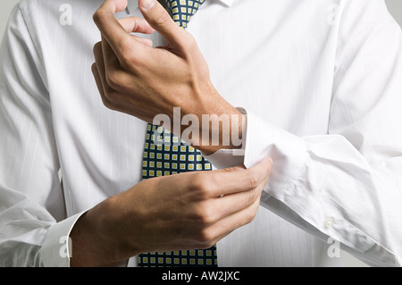 Man buttoning cuff of his shirt Stock Photo