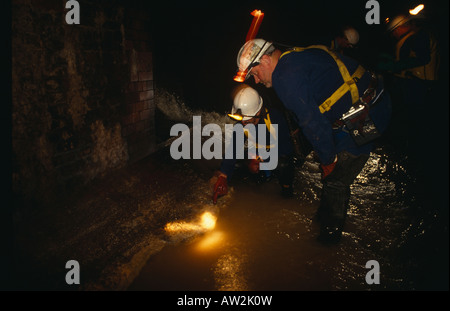 Thames Water workers inspect fat deposits from restaurants in Fleet storm sewer under City of London streets at Blackfriars. Stock Photo