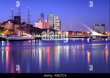Distant Puerto Madero view at dusk, with water reflections, frigate Sarmiento and Calatrava bridge. Puerto madero, Buenos Aires. Stock Photo