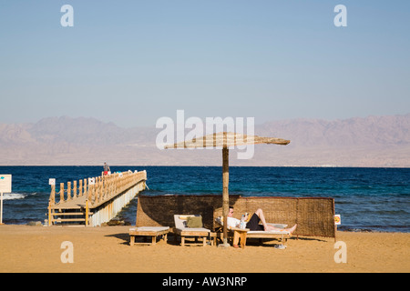 Sunshade and sunbeds on sandy beach in resort on Red Sea Riviera east coast. Taba Heights Sinai Peninsula Egypt Stock Photo