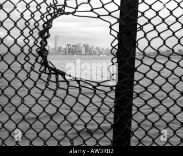 Lower Manhattan skyline viewed through fence with hole, New York City, New York, USA. Prior to 9/11 terrorist attack. Stock Photo