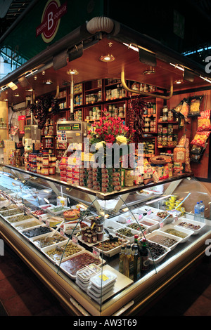 Shop stall in the Boqueria selling olives, various condiments and tinned fish products Stock Photo