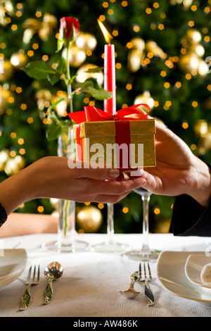 Couple during dinner party They giving each other a present Close up on hands with present Stock Photo