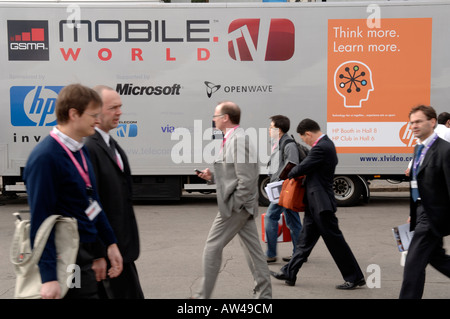 Conference delegates walking at mobile phone industry show Stock Photo