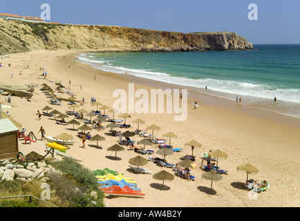 Portugal, the Algarve, Praia da Mareta beach in summer. The pousada seen on the cliffs, surfers in the sea Stock Photo