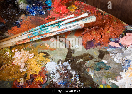 Painter's brushes and colorful pallet full of paint Stock Photo