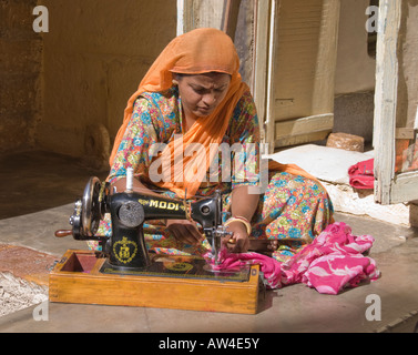Portrait of a female entrepreneur sewing on an antique sewing machine in India. Stock Photo
