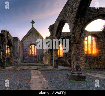 Interior of a burnt out church attacked by arsonists and left as a ruin with a blazing sunrise through the glassless windows Stock Photo