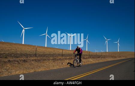 A cyclist rides past a wind turbines in the Montezuma Hills near Rio Vista California on Sept 27 2007. (Photo by Kevin Bartram) Stock Photo