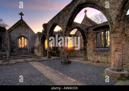 Interior of a burnt out church attacked by arsonists and left as a ruin with a blazing sunrise through the glassless windows Stock Photo