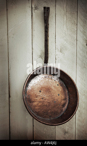 Copper pan on wooden boarded backdrop Stock Photo