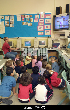 primary school teacher watching a video with his students