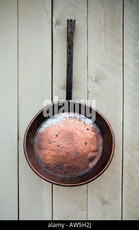 Traditional copper frying pan hanging in a kitchen Stock Photo