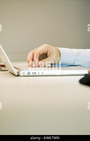 Mans hands on a computer laptop Stock Photo