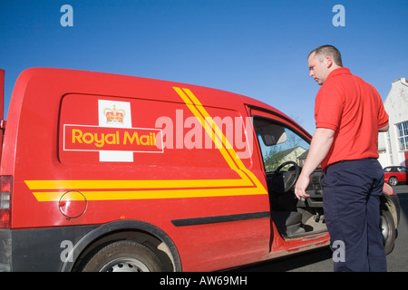 Postman post man working Red tee shirt GPO. Horizontal Narberth Post Office Red van car post bag facing Horizotal sunny blue Sky Stock Photo