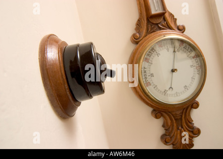 OLD FASHIONED BAKELITE LIGHT SWITCH WITH BAROMETER IN BACKGROUND Stock Photo