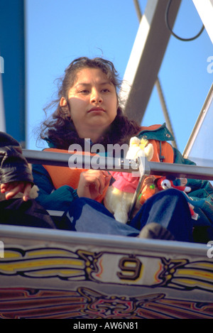 Woman age 20 riding on a carnival thrill ride. Cinco de Mayo Festival and Parade Chicago Illinois USA Stock Photo