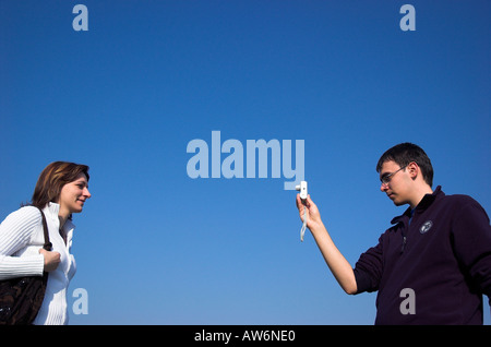 Young man taking picture of young woman Stock Photo