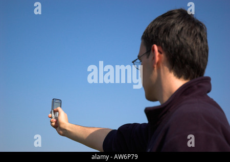 Young man using camera phone Stock Photo