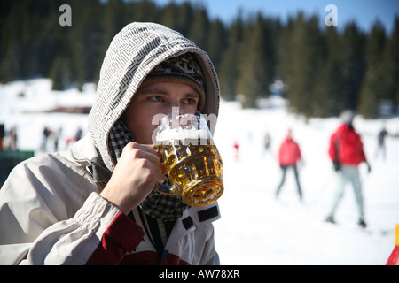 Man drinking beer on the ski slopes Stock Photo
