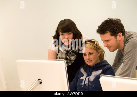 Group of three university college students working on mac computers. Stock Photo