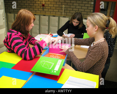 three teenage schoolgirls doing a practical exercise together Stock Photo