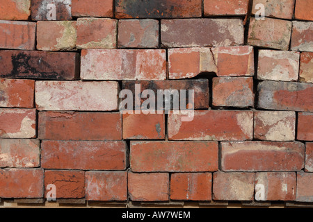 Old used reclaimed red bricks stack at a building material reclamation salvage yard Stock Photo