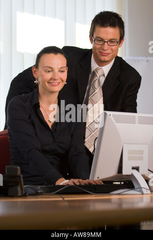A young man and woman working together in a modern office Stock Photo