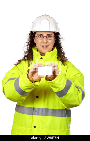 Female construction worker holding one blank card over a white background Card on focus Stock Photo