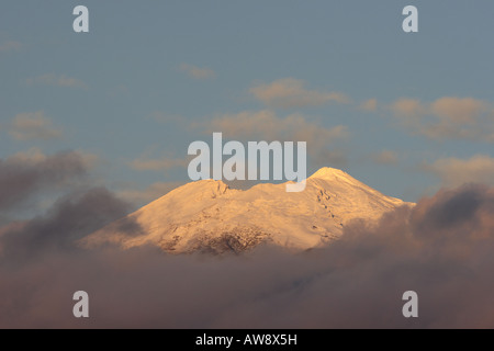 Snow covered mount Teide above the cloud glows red with the last rays from the setting sun Tenerife Canary islands Spain Stock Photo