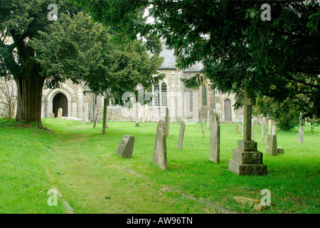 Little used side entrance pathway to St James Church in Christow on Dartmoor with gravestones and overhanging trees Stock Photo