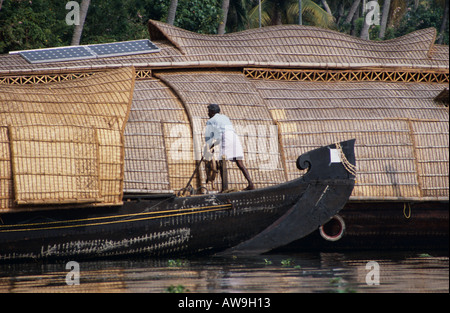 Boat man steering a houseboat on the  Keralan backwaters, Southern India Stock Photo