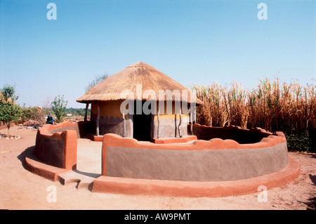 Traditional thatched rondavel with wall Stock Photo