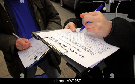 Members of the public signing a petition against possible closure of their local Post Office, High Street, New Malden, Surrey, UK. Stock Photo