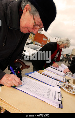 Members of the public signing a petition against possible closure of their local Post Office, High Street, New Malden, Surrey, UK. Stock Photo