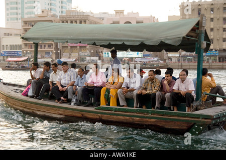 Ferry boat passengers sitting on an abra, being ferried across the Creek in Dubai, UAE. Between Deira and Bur Dubai. Stock Photo