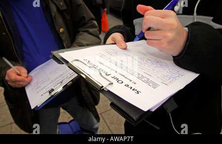 Members of the public signing a petition against possible closure of their local Post Office, High St, New Malden, Surrey, UK. Stock Photo