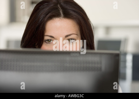 Woman in office looking at computer screen Stock Photo