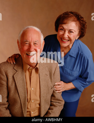A studio portrait of a senior couple smiling in their 70's. Stock Photo
