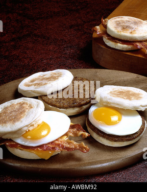 hearty breakfast two fried eggs sunny side up english muffin sandwiches sausage meat patty bacon Stock Photo