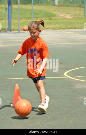 Young female playing basketball under supervision at summercamp in Michigan Stock Photo