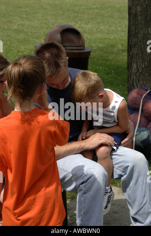 Pre-K male with a bloody knee is consoled by his Father Stock Photo