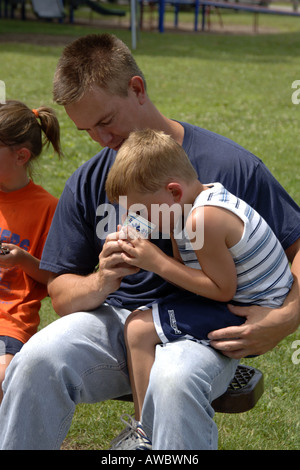 Pre-K male with a bloody knee is consoled by his Father Stock Photo