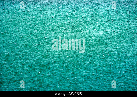 RAINDROPS FALLING ON SWIMMING POOL Stock Photo