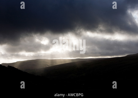 Storm clouds and sunlight over Great Pinseat mountain, Swaledale, Yorkshire Dales, England