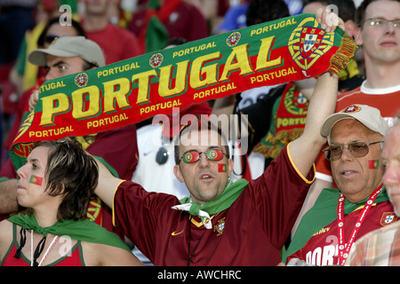 A male Portuguese supporter wearing glasses holding a scarf in the crowd during the 2006 World Cup Stock Photo