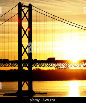Traffic crossing the forth road bridge with a warm sun setting behind it, december 2005 Stock Photo