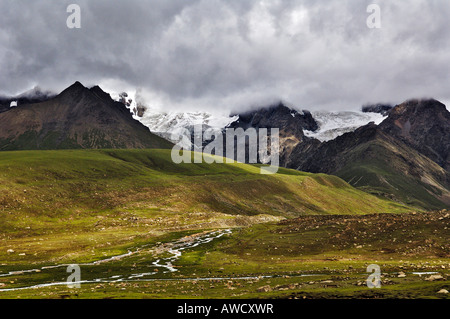 Barren mountains with glacier and brook, between Dangxiong and the Nam-Tsho-Lake, Tibet Stock Photo